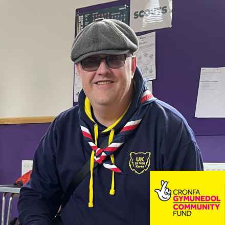 Nick Lancaster smiling in hat and sun glasses. The National Lottery Community Fund Wales logo bottom right.