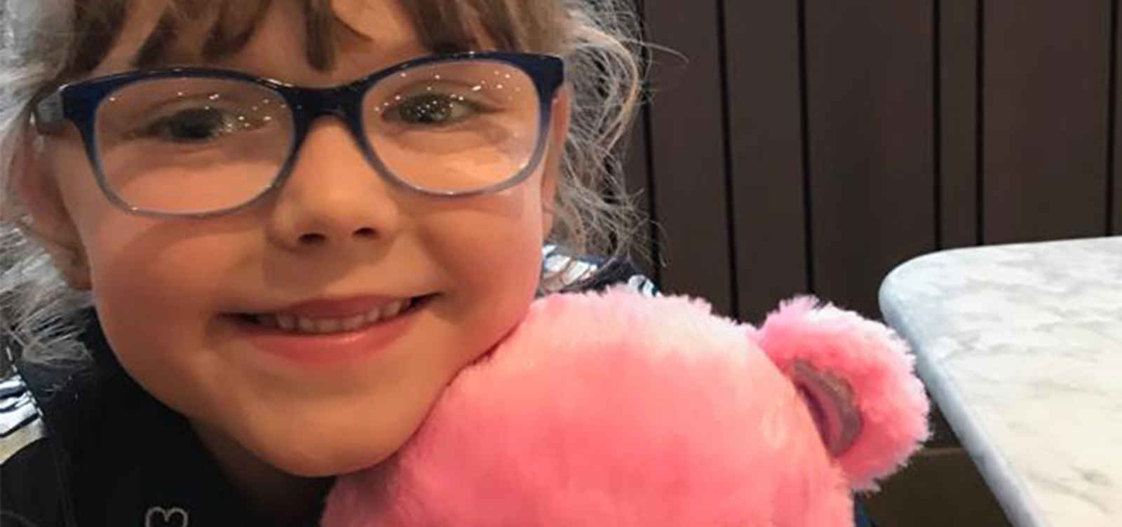 Matilda smiling with pink teddy