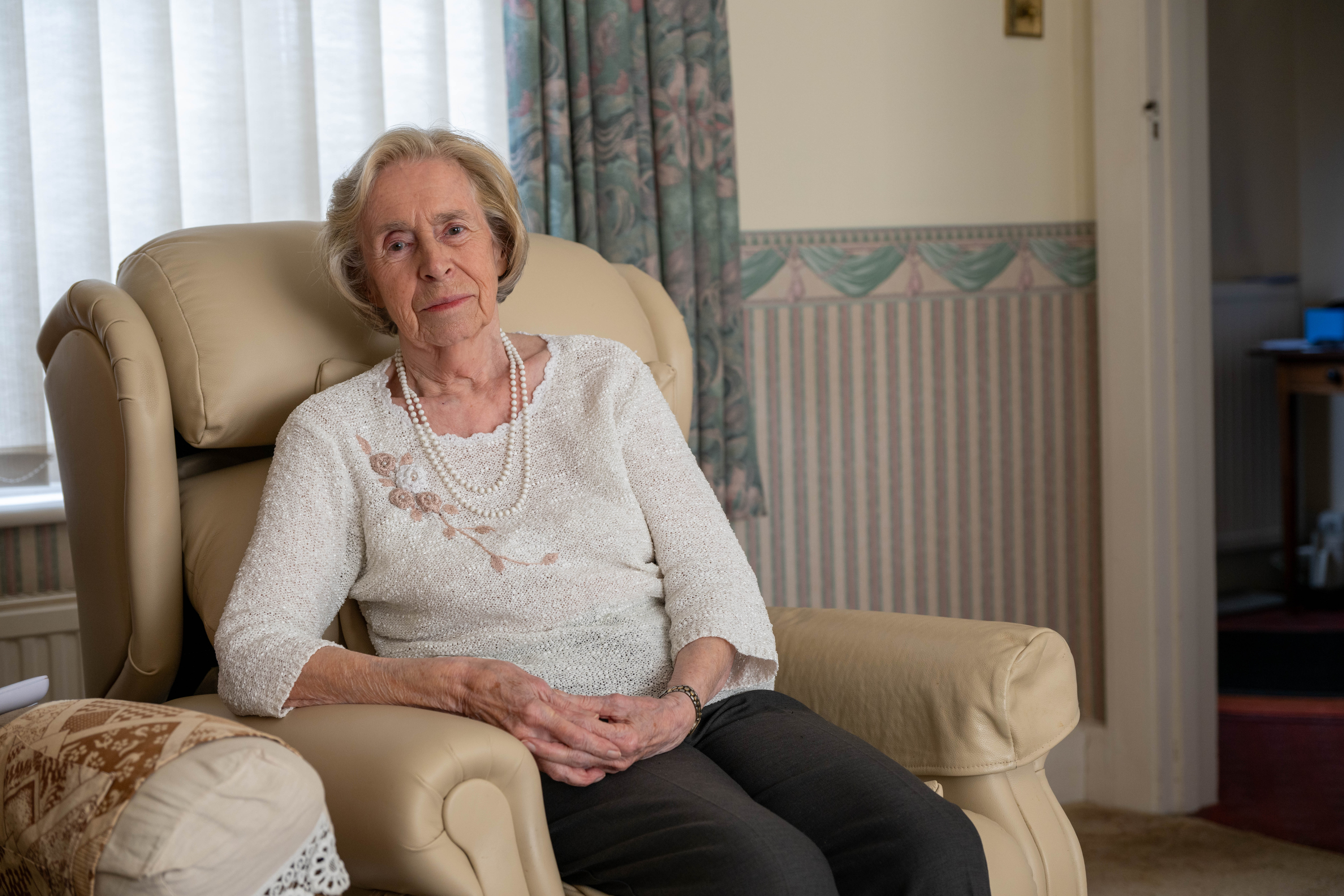 Joan sitting on a sofa looking to camera