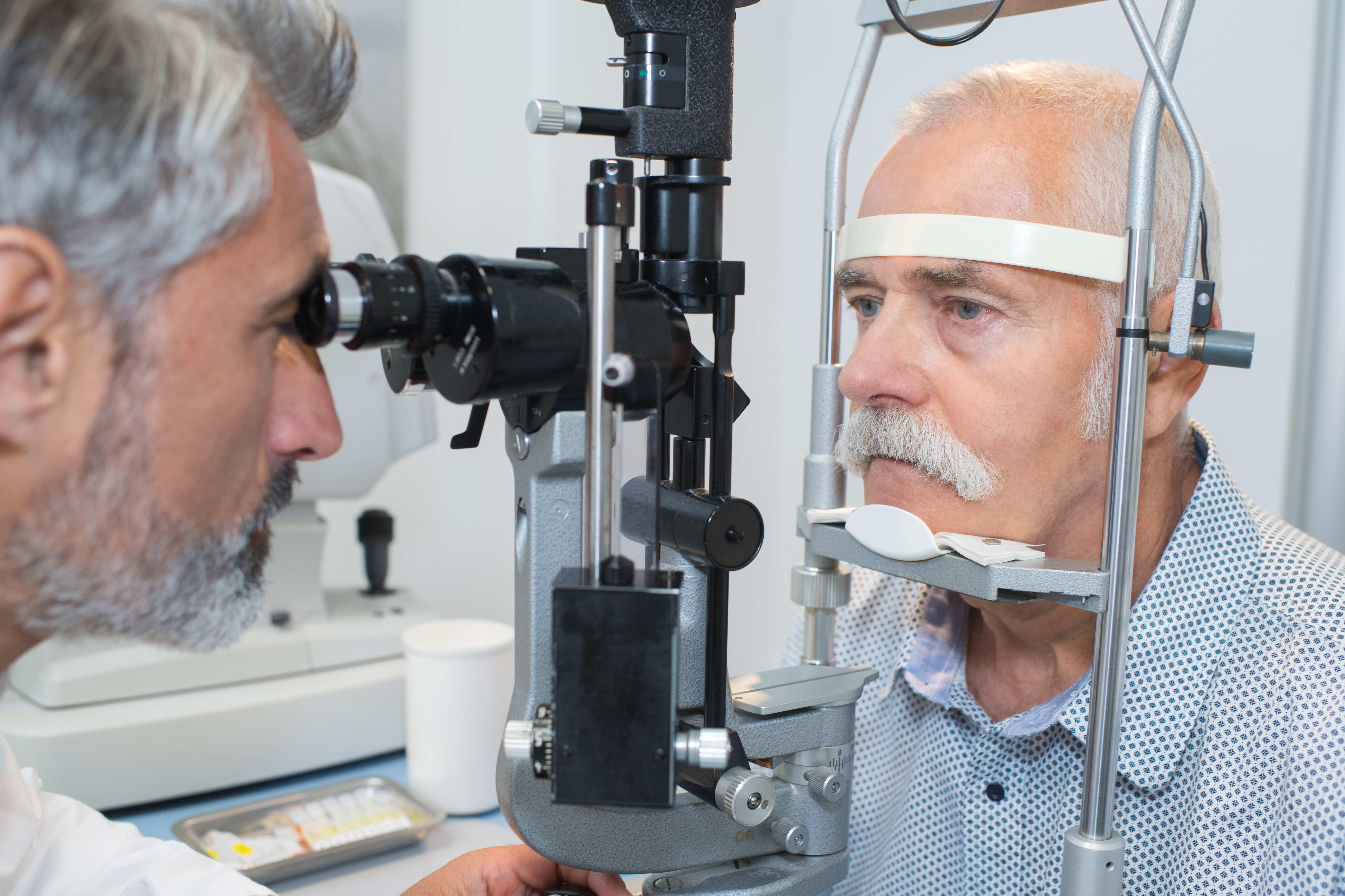 Man having eye test, leaning into eye examination machine.