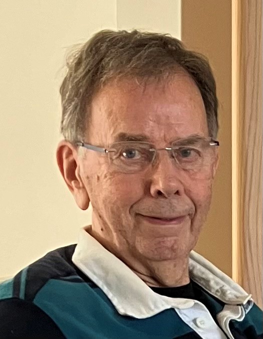 A headshot of Brian, an elderly gentleman in his 70s/80s looking to camera and smiling 
