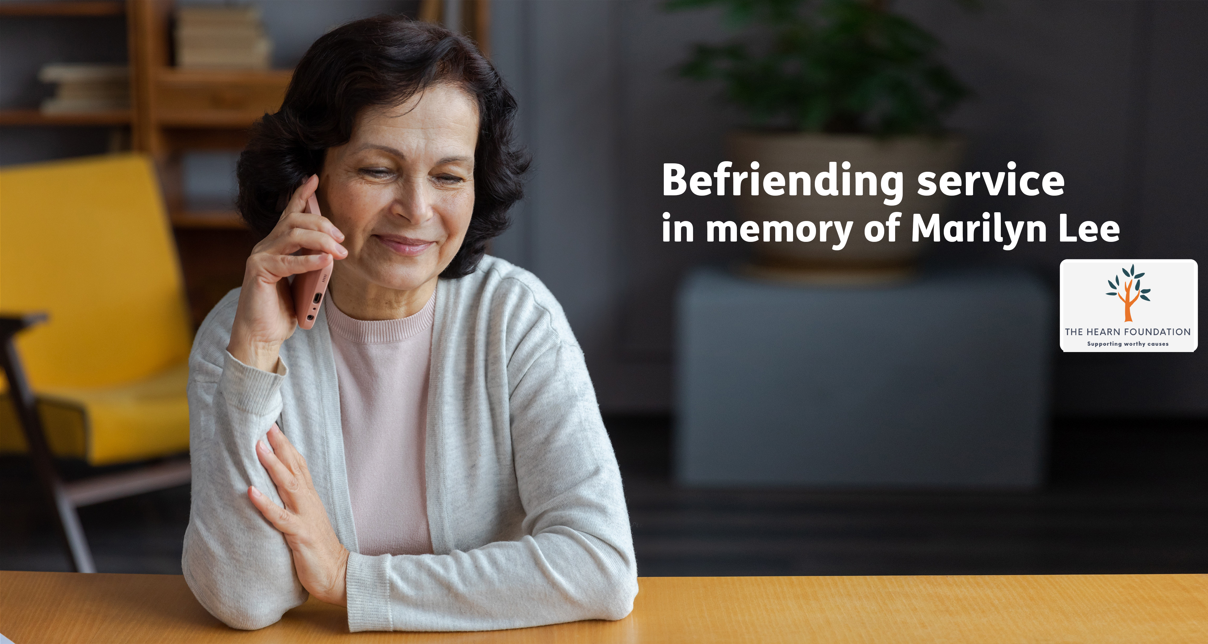 Befriending service user smiling on the phone with text 'Befriending in memory of Marilyn Lee'