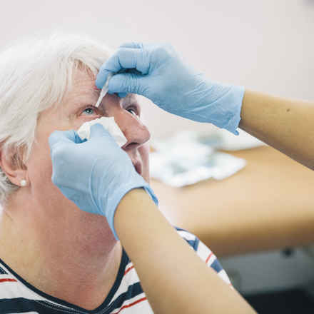 eye drops administered to senior woman