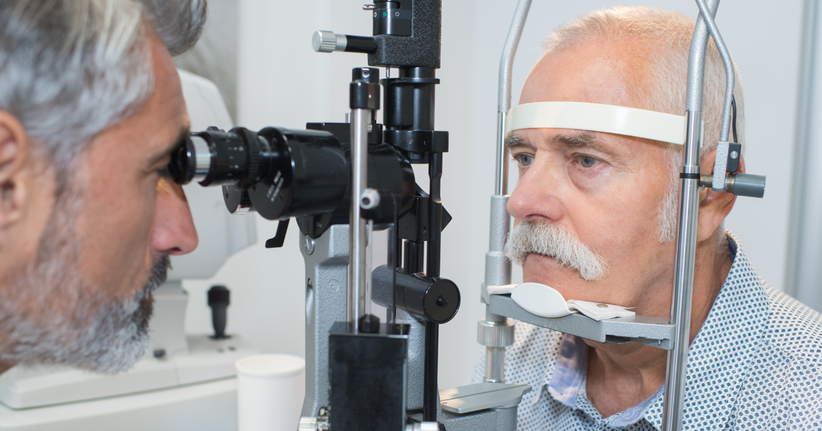 Elderly man having eye scan