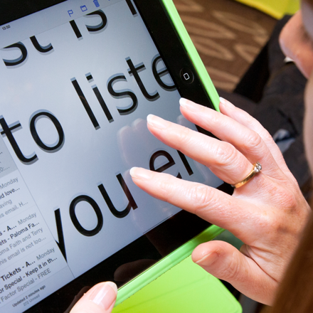 Woman using enlarged reading material on tablet