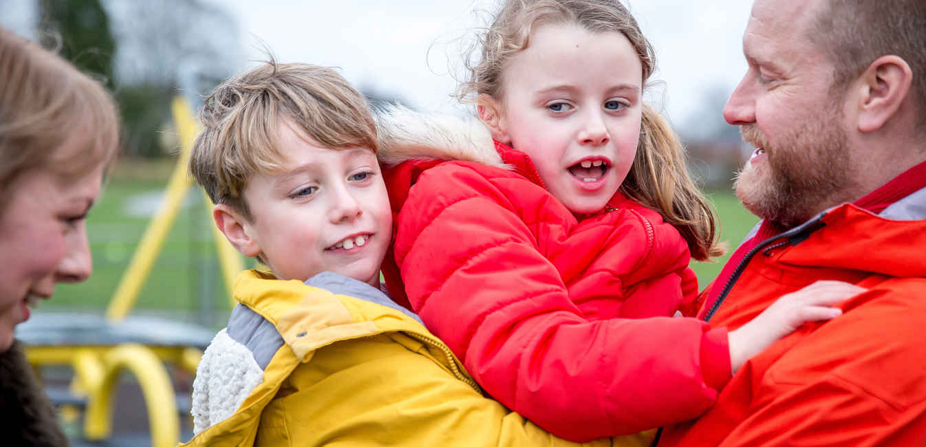 Family hugging in play area