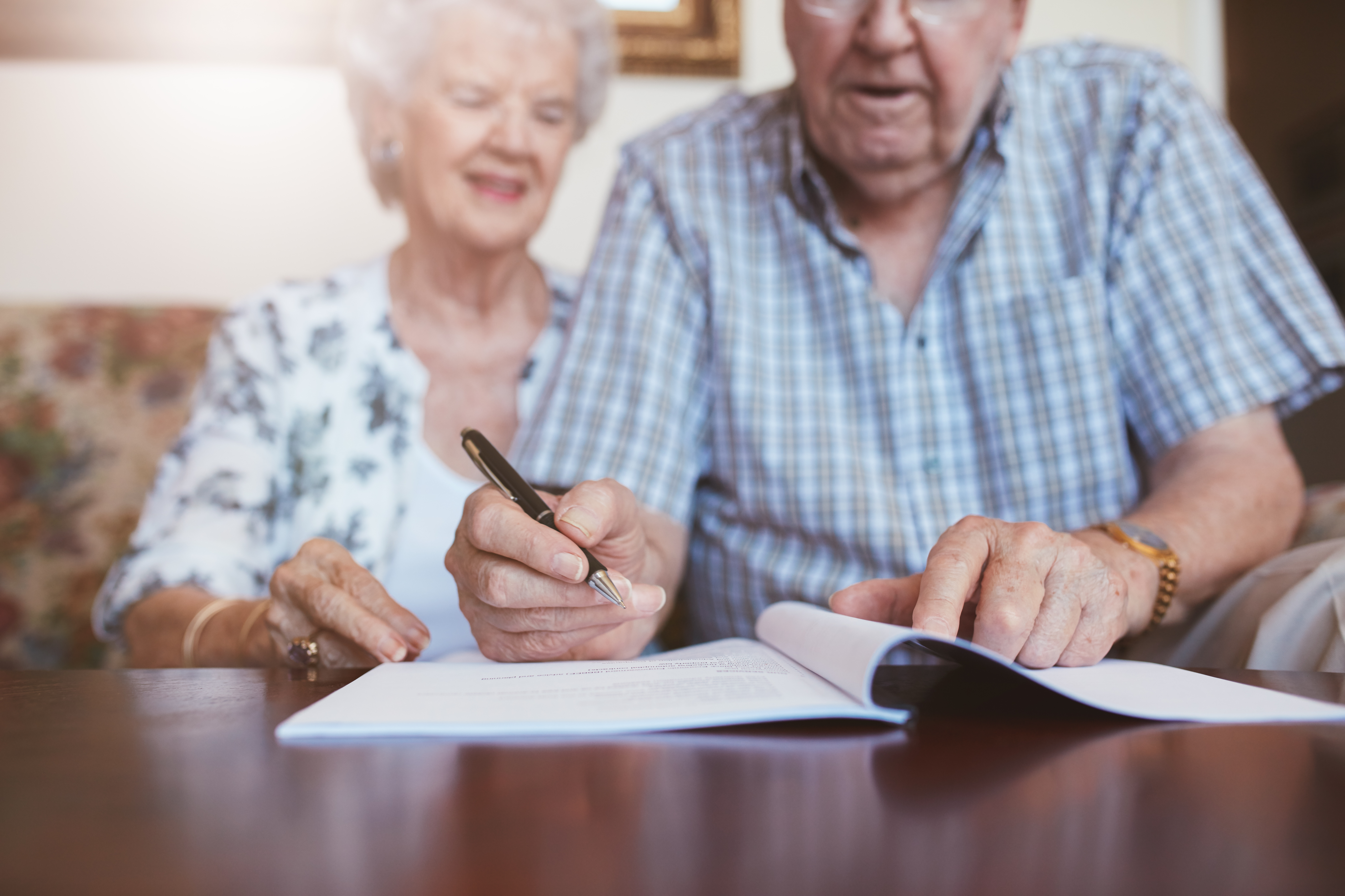 Elderly couple signing documents