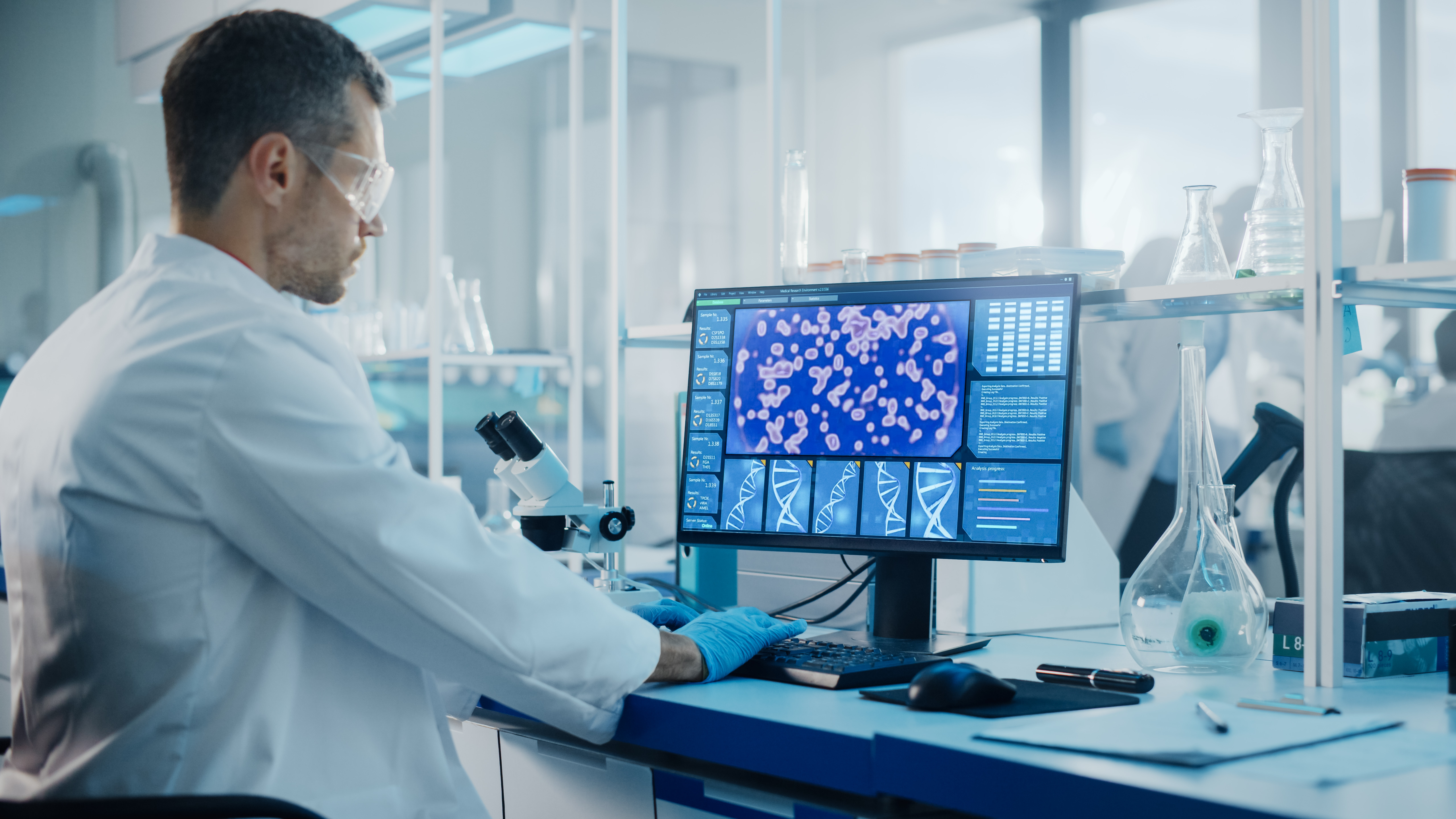 Researcher looking at a computer with DNA and RPE cells