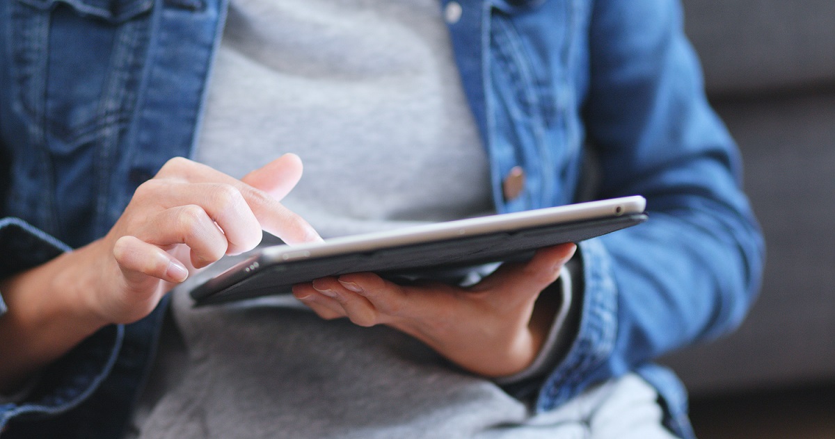 Individual reading a tablet